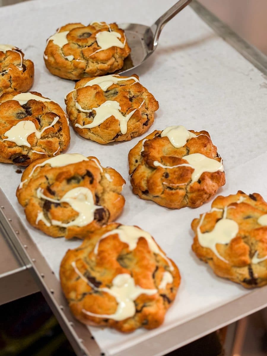Assadeira com cookies recém-saídos do forno sobre papel manteiga
